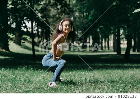 smiling young woman does morning exercises in the park. smiling young woman does morning exercises in the park. 81029138