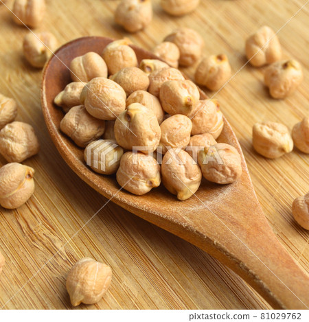 Very nutritious and a pile of fresh dry chickpeas, on wooden spoon 81029762