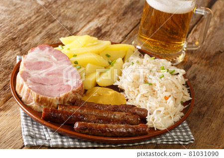 Rustic German food sausage, Kassler pork neck, sauerkraut, mustard, boiled potatoes and light beer closeup. Horizontal Rustic German food sausage, Kassler pork neck, sauerkraut, mustard, boiled potatoes and light beer closeup. Horizontal 81031090