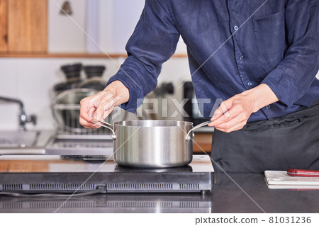 一個穿著圍裙在廚房做飯的年輕人的手烹飪男孩形象 81031236