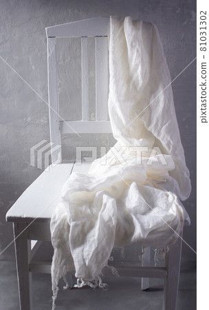 Folded tablecloth or white fabric at wooden chair and wall. Retro vintage concept Folded tablecloth or white fabric at wooden chair and wall. Retro vintage concept 81031302