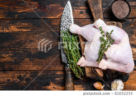 Raw chicken legs on a cutting board. Dark wooden background. Top view. Copy space 81032255