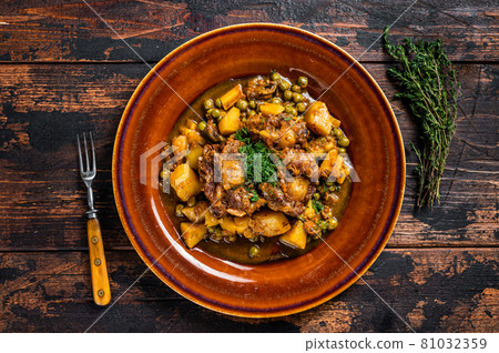 Beef veal oxtails stew with vegetables in a rustic plate. Dark wooden background. Top view Beef veal oxtails stew with vegetables in a rustic plate. Dark wooden background. Top view 81032359