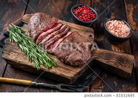 Fried Top Blade or flat iron roast beef meat steaks on wooden board with rosemary. Dark wooden background. Top View Fried Top Blade or flat iron roast beef meat steaks on wooden board with rosemary. Dark wooden background. Top View 81032695