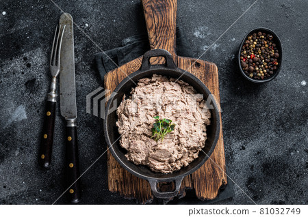 Duck pate Rillettes de Canard in a pan with greens. Black background. Top View 81032749