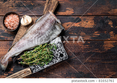 Fresh Raw cod or codfish fish on wooden board with cleaver. Dark Wooden background. Top view. Copy space Fresh Raw cod or codfish fish on wooden board with cleaver. Dark Wooden background. Top view. Copy space 81032761