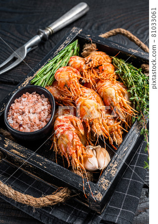 Boiled Greenland Prawn Shrimp in a wooden tray with herbs. Black wooden background. Top view Boiled Greenland Prawn Shrimp in a wooden tray with herbs. Black wooden background. Top view 81033061