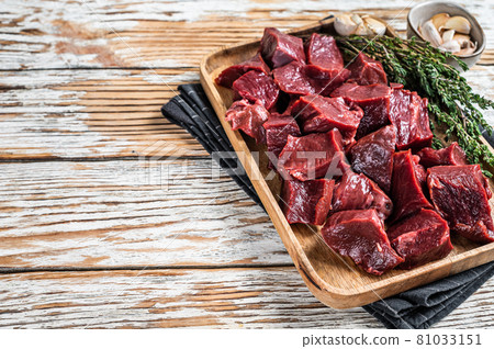 Raw sliced Beef or veal heart in a wooden tray with thyme. White wooden background. Top View. Copy space 81033151