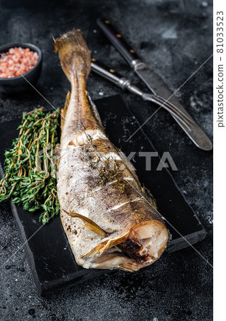 Roasted cod white fish with thyme on marble board. Black background. Top view Roasted cod white fish with thyme on marble board. Black background. Top view 81033523