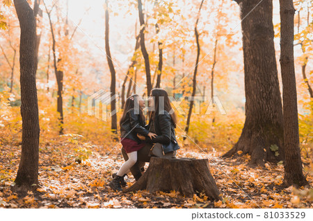 Little girl playing with mother in the autumn park Little girl playing with mother in the autumn park 81033529