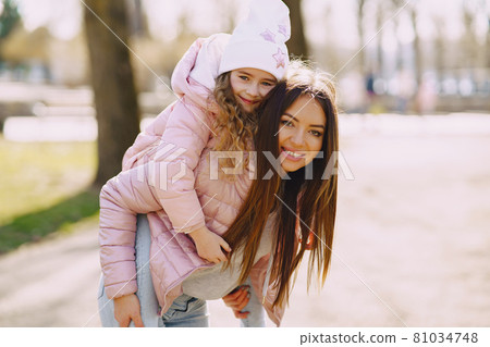 Mother with daughter playing in a spring park 81034748