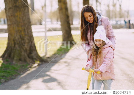 Mother with daughter in a spring park with skate 81034754