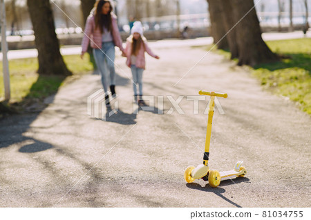 Mother with daughter in a spring park with skate 81034755
