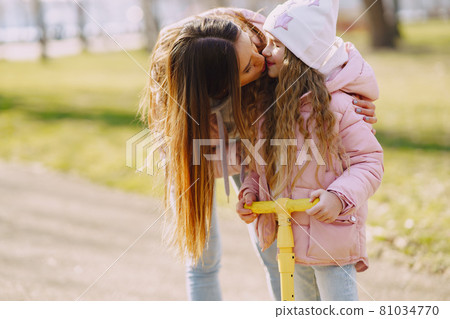 Mother with daughter in a spring park with skate 81034770