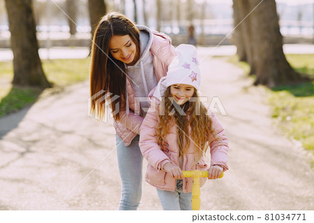 Mother with daughter in a spring park with skate 81034771
