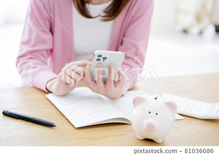 A woman holding a household account book A woman holding a household account book 81036086