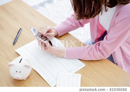 A woman holding a household account book A woman holding a household account book 81036088