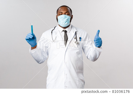 Covid-19, coronavirus patient treatment and disease concept. Satisfied, professional infectionist or laboratory doctor, show thumb-up proud of creating virus vaccine, hold vial with blue liquid 81036176