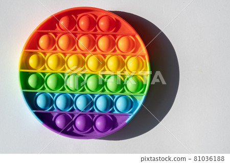 Round multicolored pop it toy and shadow on a white background Round multicolored pop it toy and shadow on a white background 81036188