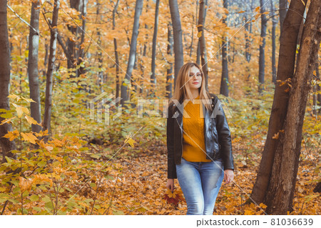 Cute smiley woman holding autumn leaves in fall park. Seasonal, lifestyle and leisure concept. 81036639