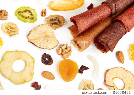 Neatly stacked fruit lozenge different colors and nuts.  81038491