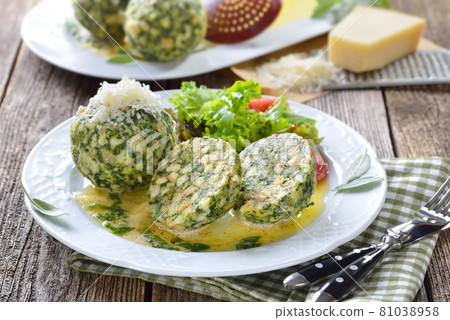 South Tyrolean spinach dumplings made of white bread and spinach, served with butter and parmesan 81038958