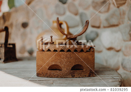 Close up of an antique and rusty iron on wood table background. Houseworks. 81039295