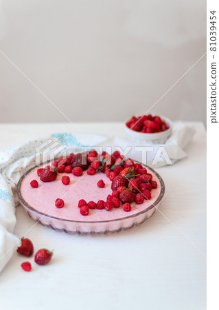 Homemade cheesecake slice with fresh raspberries and mint leaves on white plate on the table. Healthy organic summer dessert Homemade cheesecake slice with fresh raspberries and mint leaves on white plate on the table. Healthy organic summer dessert 81039454
