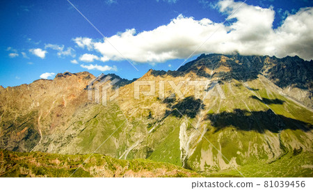 Beautiful panoramic view from the grassy hill to the Kazbek mountains. 81039456