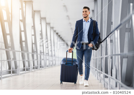 Ready For Trip. Handsome Arab Guy Walking With Suitcase At Airport Terminal 81040524