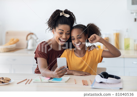 Emotional mother and daughter taking selfie together Emotional mother and daughter taking selfie together 81040536