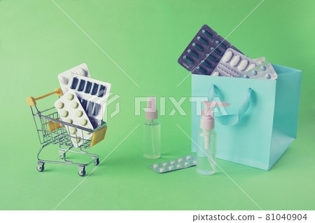 Toy trolley with various pills and capsules, spray on a bright background with copy space, the concept of medicine, pharmacy, drug delivery, sales 81040904