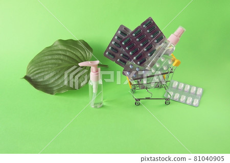 Toy trolley with various pills and capsules, spray on a bright background with copy space, the concept of medicine, pharmacy, drug delivery, sales 81040905