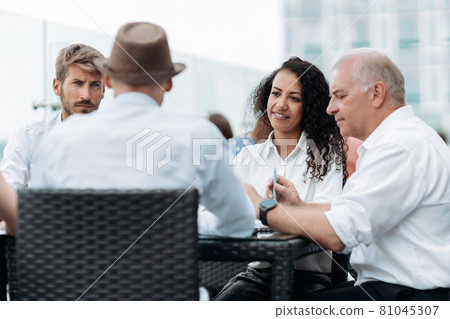international group of business people sitting at a discussion table . international group of business people sitting at a discussion table . 81045307