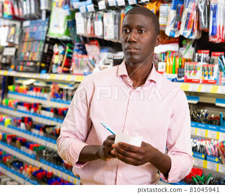 Portrait of Afro American man choosing ball pen at stationery store Portrait of Afro American man choosing ball pen at stationery store 81045941