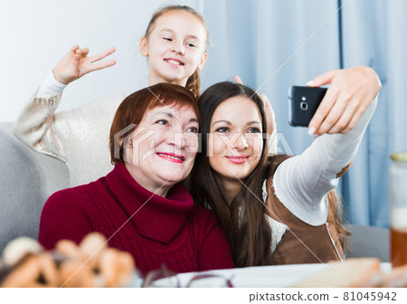 Three generations of happy women taking selfie 81045942