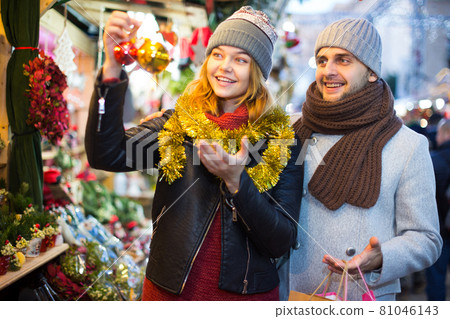 Girl with boy choosing decorations at Christmas market Girl with boy choosing decorations at Christmas market 81046143