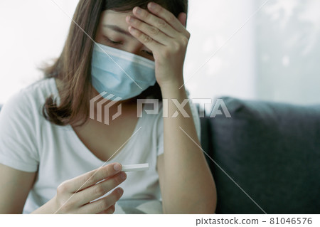 Asian woman using COVID-19 antigen test. Asian woman using COVID-19 antigen test. 81046576