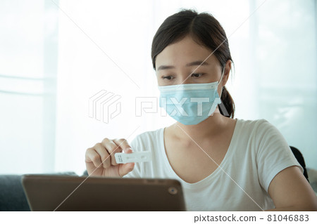 Asian woman making an online video call with doctor. 81046883