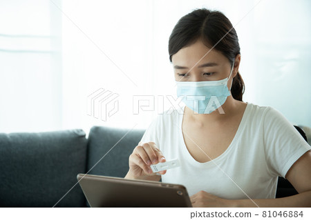 Asian woman making an online video call with doctor. 81046884