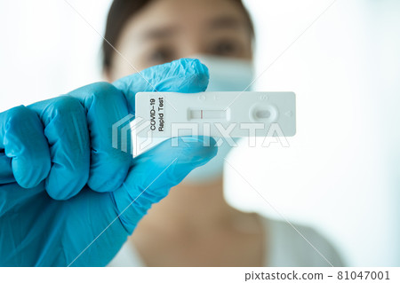 Woman using COVID-19 antigen test. Woman using COVID-19 antigen test. 81047001