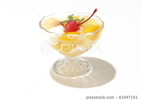 在白色背景上拍攝了含有牛奶罐、菠蘿、芒果、白桃、櫻桃和橙子等水果的水果潘趣酒。 81047191
