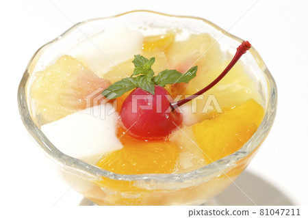 Photographed a fruit punch containing fruits such as milk cans, pineapples, mangoes, white peaches, cherries, and oranges on a white background. 81047211