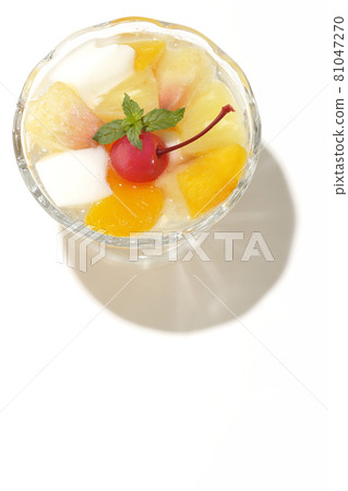 A bird's-eye view of a fruit punch containing milk cans, pineapples, mangoes, white peaches, cherries, oranges, etc. on a white background 81047270
