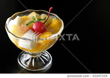 Photographed a fruit punch containing fruits such as milk cans, pineapples, mangoes, white peaches, cherries, and oranges on a black background. Photographed a fruit punch containing fruits such as milk cans, pineapples, mangoes, white peaches, cherries, and oranges on a black background. 81047334