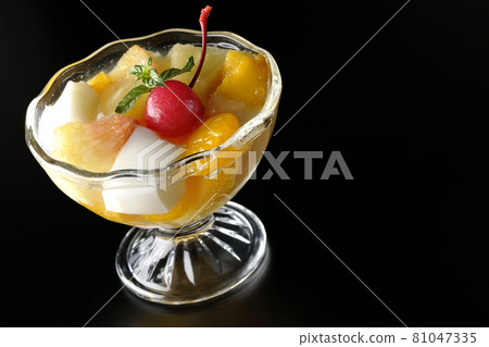 Photographed a fruit punch containing fruits such as milk cans, pineapples, mangoes, white peaches, cherries, and oranges on a black background. Photographed a fruit punch containing fruits such as milk cans, pineapples, mangoes, white peaches, cherries, and oranges on a black background. 81047335