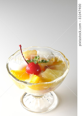 Photographed a fruit punch containing fruits such as milk cans, pineapples, mangoes, white peaches, cherries, and oranges on a white background. 81047400