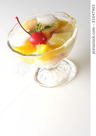 在白色背景上拍攝了含有牛奶罐、菠蘿、芒果、白桃、櫻桃和橙子等水果的水果潘趣酒。 在白色背景上拍攝了含有牛奶罐、菠蘿、芒果、白桃、櫻桃和橙子等水果的水果潘趣酒。 81047403