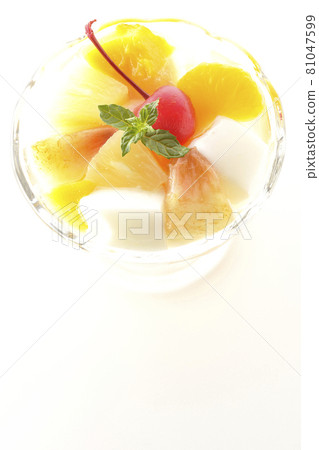 A bird's-eye view of a fruit punch containing milk cans, pineapples, mangoes, white peaches, cherries, oranges, etc. on a white background 81047599