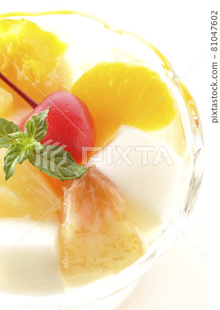 A bird's-eye view of a fruit punch containing milk cans, pineapples, mangoes, white peaches, cherries, oranges, etc. on a white background 81047602